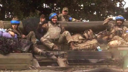 Ukrainian soldiers sit on an armoured vehicle near the Russian border