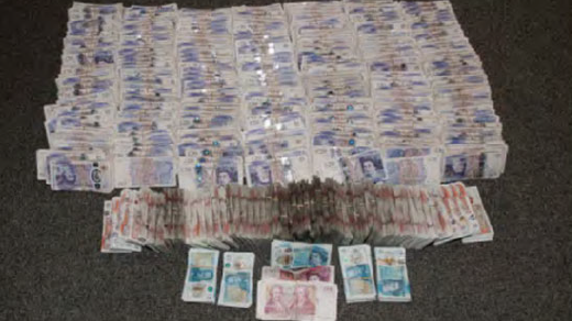 multiple piles of British cash on a carpet