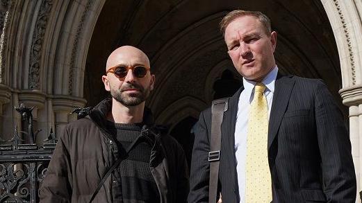 Carlo Palombo and Tom Hayes stand outside the Royal Courts of Justice