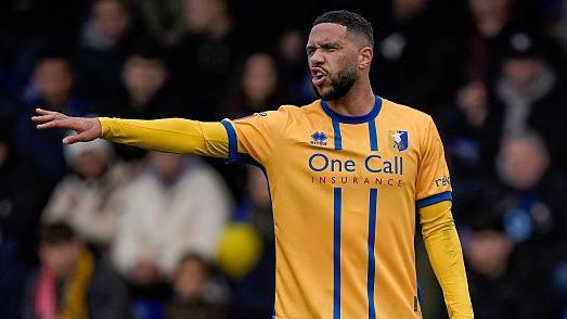 Tyler Roberts points out instructions to team-mates during a game for Mansfield 