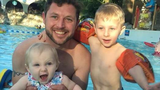 Jim Barrow in a swimming pool with his children Archie and Izzy