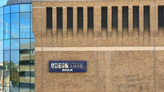 A purple Odeon sign on a brown building