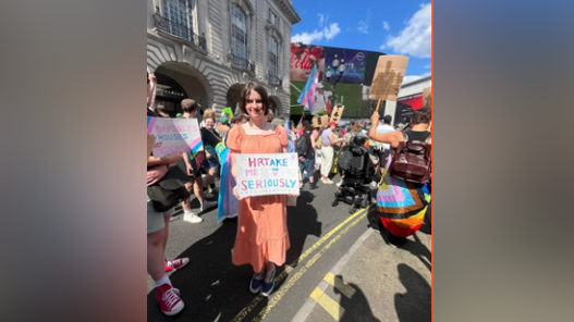 Raya holding a placard at London Trans Pride 