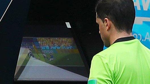 A referee uses VAR at the World Cup