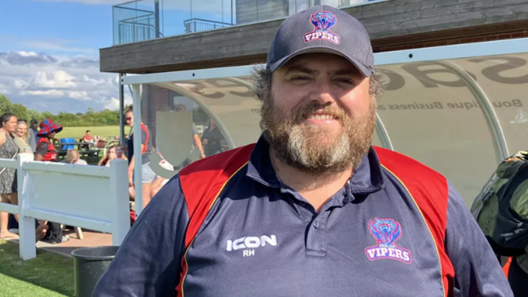 Anglian Vipers chairman Rob Humphries poses by the dugout, wearing a Vipers-branded hat and some coaching kit