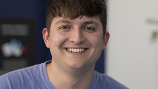 National Union of Students for Wales president Deio Owen in a T-shirt smiling