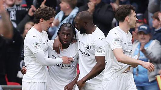 Abdul Abdulmalik is congratulated after teeing up Boreham Wood's first goal