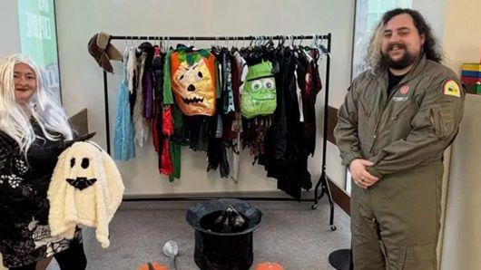 two adults who are helping out at the costume swap scheme 