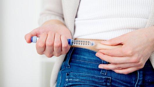 A woman injecting herself with insulin