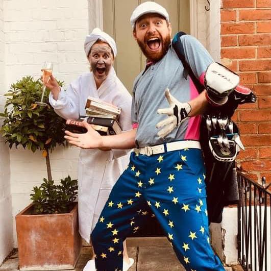 Tom Price, wearing bright star-print golf trousers and carrying clubs, poses outside his house. Beth, in a white dressing gown with a face mask, holds books and a glass of fizz beside him.