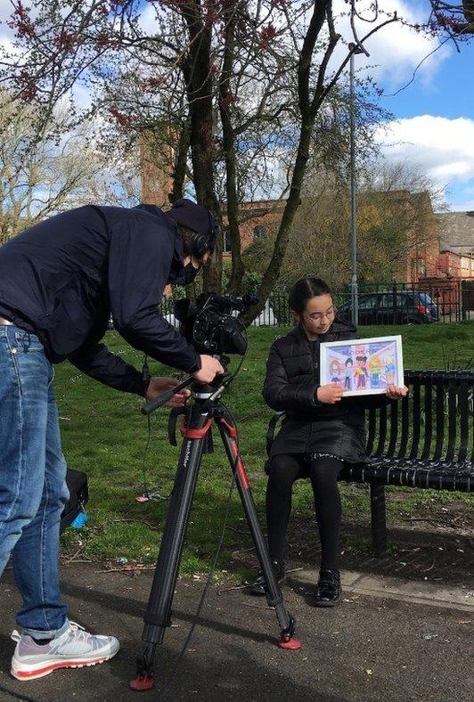 Camera operator films a child.