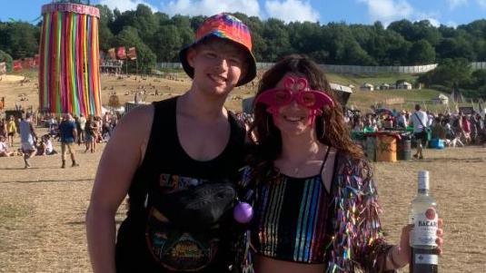 A couple in bright pink sun glasses and a boy in a bucket hat