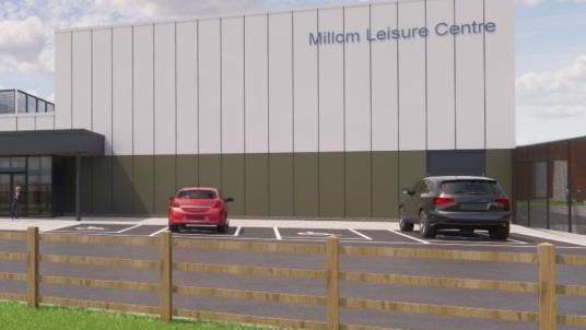 An artist's impression of the outside of the complex. It is a large, white square building with the sign Millom Leisure Centre. There is a car park with two cars and disabled parking bays. 