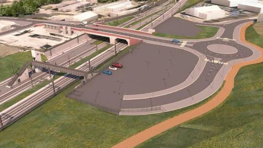 A computer-generated image showing an aerial view of the proposed new station. A car parking area with new road and roundabout is shown to the right  of the image with railway tracks and a road bridge and footbridge leading to the platforms to the left.