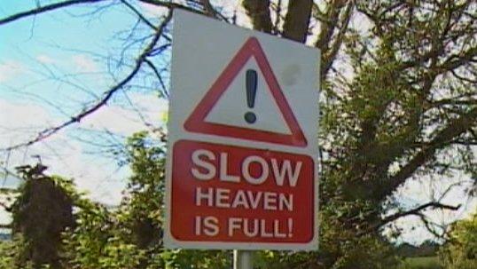 "Slow - Heaven is full" sign