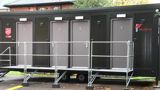 Black modular building with four grey doors