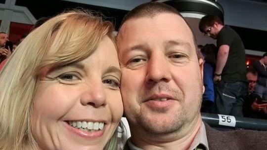 Selfie of Mr Clements and his wife Sarah sitting inside a theatre, smiling towards the camera. 