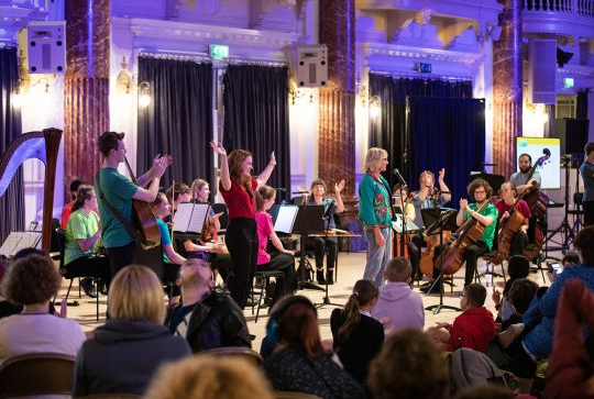 An orchestra perform in a concert hall