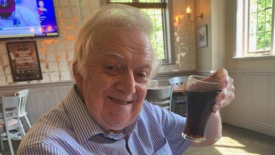 Alan Spencer holding a drink in a pub