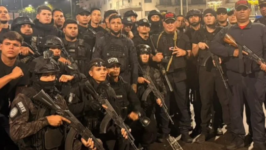 Interior Minister Diosdado Cabello poses with a group of uniformed men, some of whom are holding machine guns, with others wearing helmets and/or body armour.