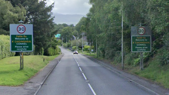 A google view of the A85 entering Connel. There is a single car on the road approaching two 30mph speed limit signs which say welcome to connel