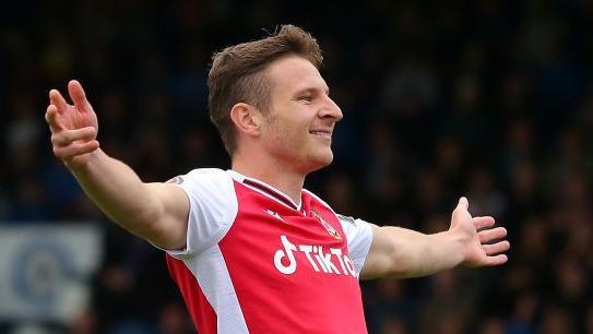 Paul Mullin with outretched arms celebrates a goal for Wrexham in 2021