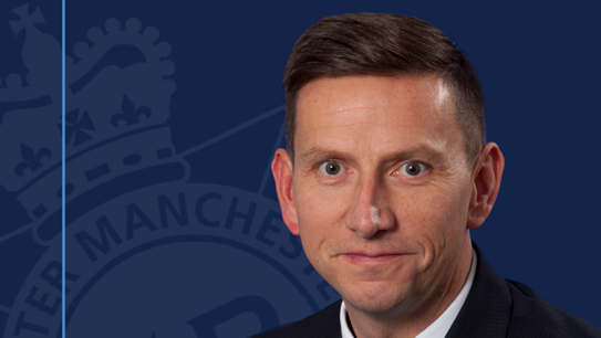 Rob Cousen's profile published by GMP in 2021 - Photo of man with brown hair in a suit, looking happy but not smiling. The logo at the right of the photo