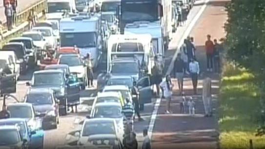 A CCTV image of the closed part of the M6 with cars parked up and people walking around the carriageway