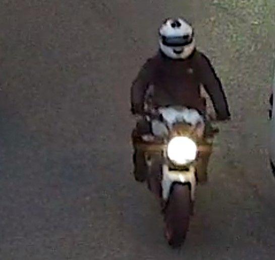 CCTV image of the motorcyclist from a front view showing him in black on a white motorbike with a big circle headlamp.