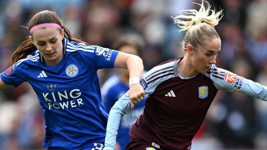 Aston Villa and Leicester players battle for the ball.