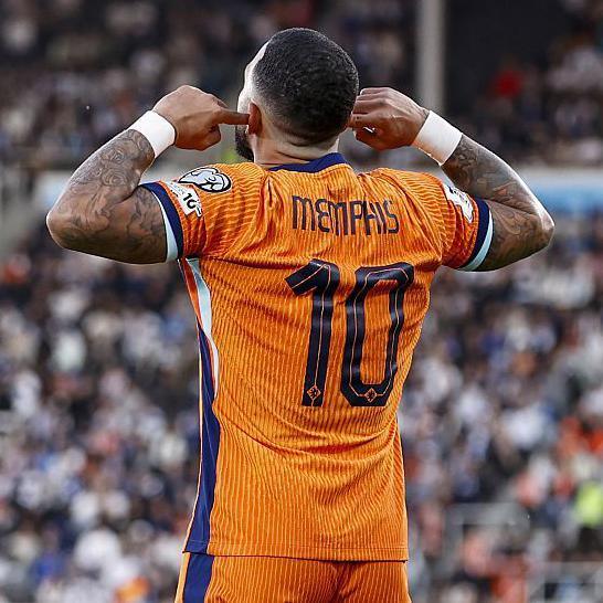 Memphis Depay celebrates with fingers in his ears