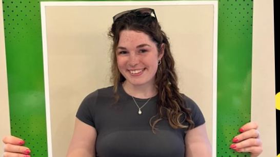 Mae'r llun yn dangos merch ifanc yn gwenu i'r camera.