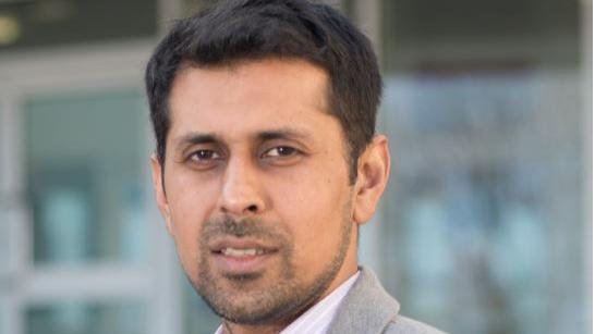 Head-and-shoulders photograph of Burnley Council Leader Afrasiab Anwar, wearing a light grey suit jacket