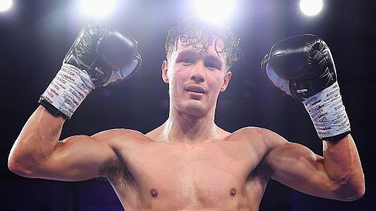 Garan Croft holds up his hands in celebration after victory