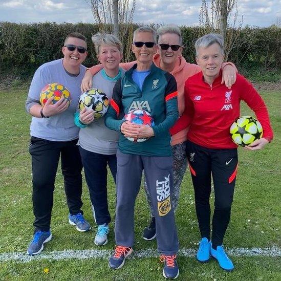 Women holding footballs