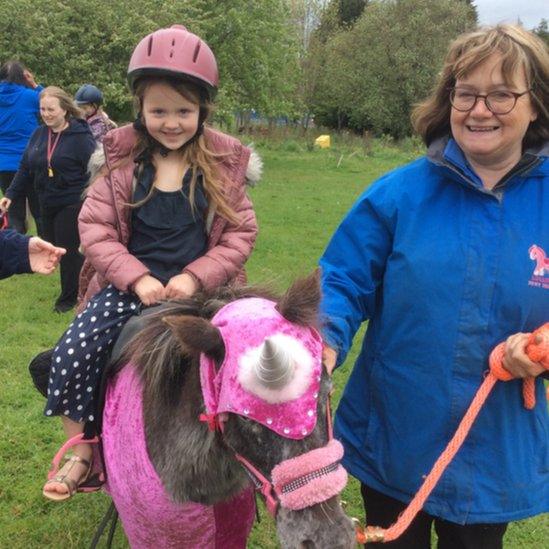 Child riding on a donkey.