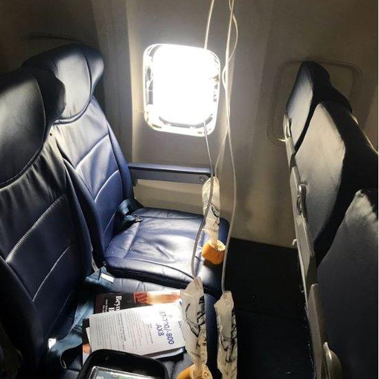 Passenger images shows a broken window and oxygen masks deployed