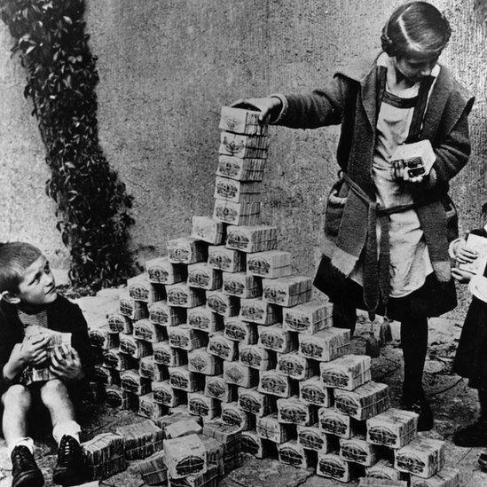 Children in Germany using mark notes to play of building a tower in 1923