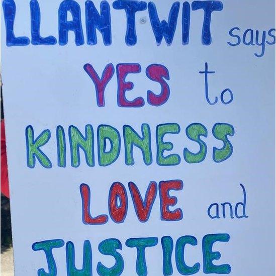 One placard said the town "says yes to kindness, love and justice for everyone"