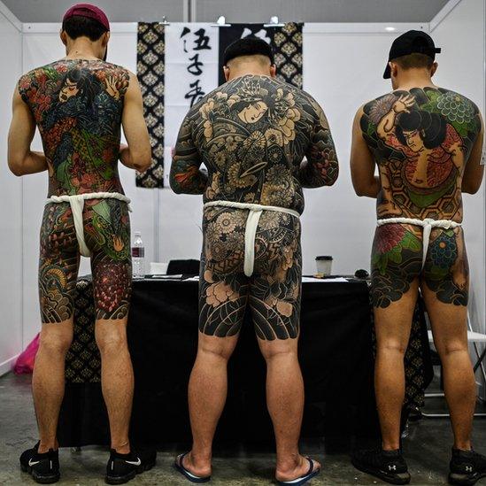 The half-naked men with tattoos