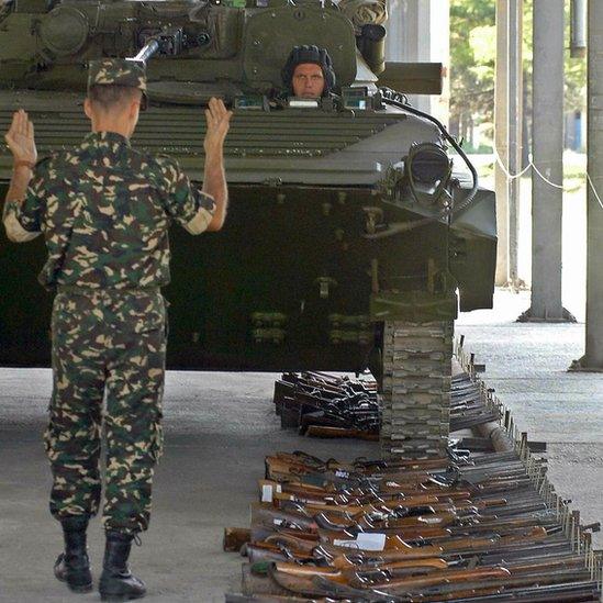 Macedonian army tank rolls over guns gathered during a voluntary disarmament drive in the volatile Balkans country (9 July 2004)