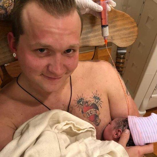 Dad breastfeeds daughter