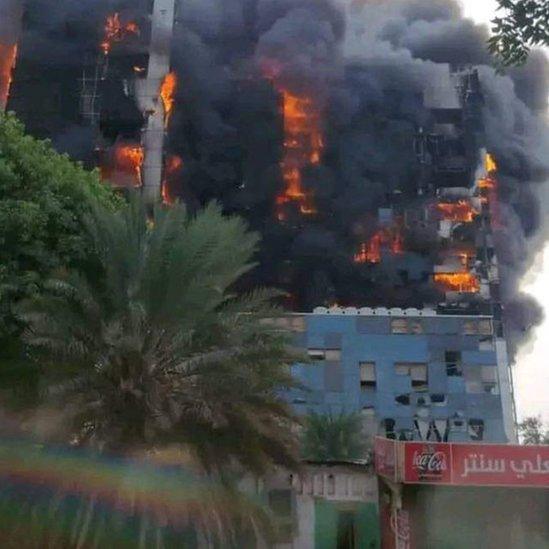 Thick, black smoke rising as flames engulfing an office building