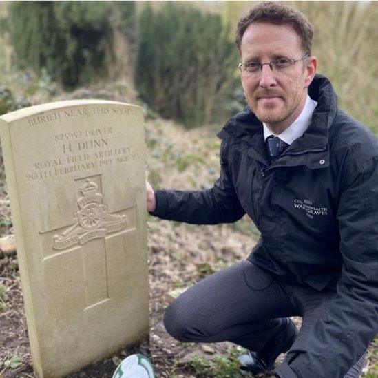 Man kneeling by gravestone