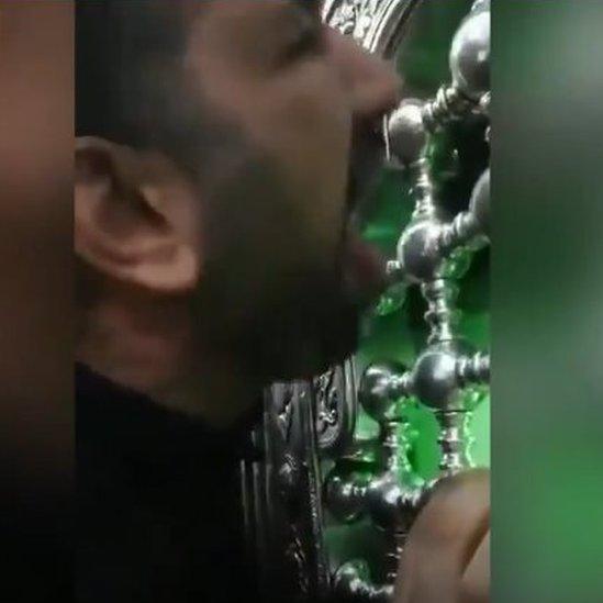 man licking holy shrine in Qom Iran