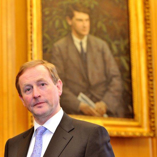 Enda Kenny was photographed under a portrait of Michael Collins on his first day in office in 2011