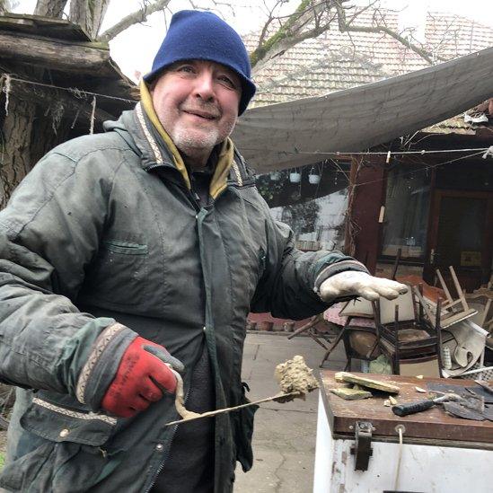 Pastor Tibor Varga with basic barrel stove for migrants