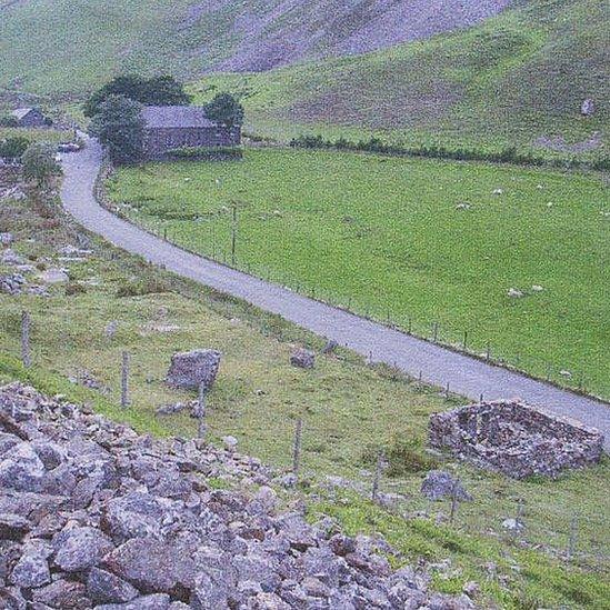 Safle'r hen gapel yn Nrws-y-coed gyda'r capel newydd i'w weld yn y pellter