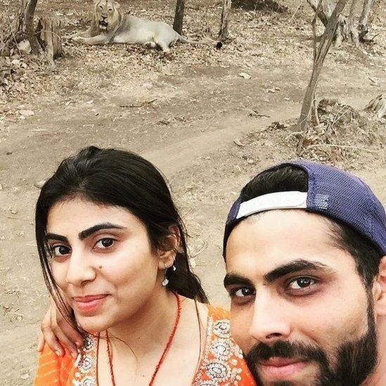 Ravindra Jadeja and his wife Reeva pose with an Asiatic lion at Gujarat state's Gir wildlife sanctuary while on safari.