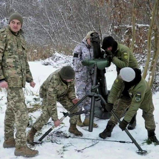 Antonina and Oleksandr with other soldiers using mortars in the snow